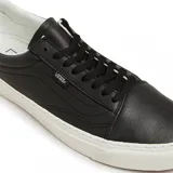 Zapatillas Vans Old Lux de cuero negro con suela blanca y detalle de gamuza en el talón.
