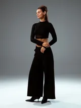 Top negro con cuello alto, mangas largas de tul y corte crop.