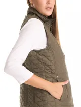 Chaleco capitoneado color verde oliva, con cuello alto, cierre frontal completo y bolsillos laterales. El interior está completamente forrado en símil piel para mayor calidez.