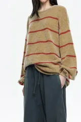 Sweater de punto largo con corte oversize, confeccionado en una mezcla de mohair y lana. Presenta un diseño a rayas horizontales en color mostaza y rojo, con escote barco redondeado y mangas largas holgadas.