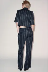 Pantalón de tiro medio de ZARA Woman Collection, confeccionado con mezcla de lino. Presenta diseño de rayas diplomáticas, bolsillos laterales, pinzas en el delantero y cierre frontal con cremallera, botón y ganchos metálicos.