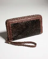Billetera rectangular de cuero marrón con cierre perimetral y correa de muñeca. Presenta un diseño decorativo con costuras en forma de X en la parte frontal.