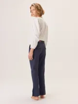 Pantalón de vestir azul marino, corte cigarette con pierna angosta y abertura en el bajo. Presenta costuras en contraste color beige y un botón marrón en la cintura.