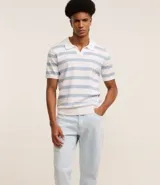 Pantalón de jeans celeste, corte slim, con bolsillos delanteros y traseros, trabillas en la cintura y cierre tradicional con botón y cremallera.