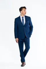 Traje de dos piezas color azul intenso, compuesto por un saco de corte clásico con solapas y un pantalón de vestir de corte recto. Confeccionado en tejido de poliviscosa.