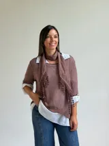 Sweater de punto color marrón chocolate con cuello redondo, mangas tres cuartos y diseño asimétrico. Incluye un pañuelo a juego con detalles de puntilla en los bordes.