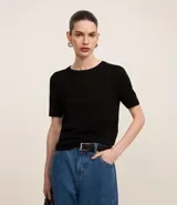 Blusa de punto color negro, de manga corta y cuello redondo.