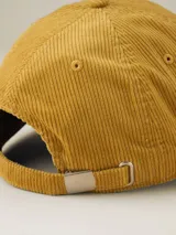 Gorra de béisbol color ocre, confeccionada en pana con visera curva y botón superior.