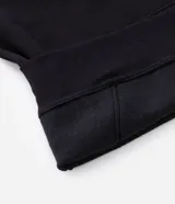 Buzo con capucha ajustable y bolsillo canguro delantero, confeccionado en tejido de algodón con felpa. Presenta un diseño de corte holgado con una estampa lineal de montañas en el centro del pecho.