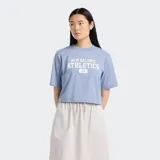 Remera celeste de corte cropped, con cuello redondo y mangas cortas. Estampado frontal con el logo de New Balance Athletics en blanco.