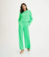 Pantalón recto de crepé color verde neón, con cintura alta acabada en forma ondulada. Prenda con trabillas, botón tipo escudo, bolsillos delanteros y traseros y detalle de pliegues delanteros.