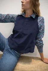 Chaleco de pana azul marino con cuello a la base, espalda irregular y terminación desflecada.