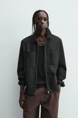 Cazadora azul marino de corte regular fit, confeccionada en tejido técnico repelente al agua. Presenta cuello subido, manga larga, bolsillos de vivo en cadera, bolsillo interior y acabados en rib en puños y bajo. Cierre frontal de cremallera oculta por solapa con botones a presión.