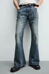 Jeans flare fit de tiro medio, confeccionados en denim de algodón color azul con efecto deslavado. Diseño ajustado en la parte superior y abierto en campana desde la rodilla, con cinco bolsillos y cierre frontal con cremallera y botón.