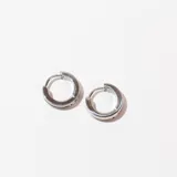 Par de caravanas plateadas de acero con forma de aro grueso con una ranura horizontal en el centro.
