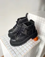 Botas acordonadas de cuero vacuno con efecto desgastado, de caña media y suela track robusta. Presentan costuras a la vista en tono contrastante y tirador en la parte trasera.