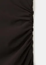 Vestido largo negro de corte entallado y diseño asimétrico, sin mangas, con detalle de capa en el cuello y fruncidos laterales.