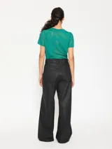 Pantalón de jean negro engomado de tiro alto, corte oversize y pierna ancha.