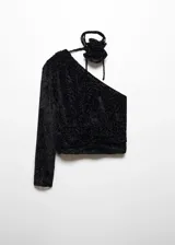 Blusa asimétrica de terciopelo negro con textura de flores en relieve, diseño de un solo hombro con manga larga y detalle de lazo con flor en el cuello.