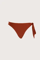 Bombacha de bikini color terracota con diseño asimétrico y detalle de lazo lateral para anudar.