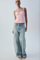 Top negro con estampado de lunares blancos, escote halter y diseño estructurado tipo corset con copas fruncidas en el centro.