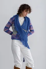 Saco de lana tejido a mano con diseño de rayas horizontales en tonos azul, violeta, rosa y blanco. Presenta un chaleco azul tejido con flecos que se ata al frente.