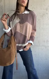 Sweater de punto con diseño de bloques de color en tonos tierra y beige, de corte oversize, cuello redondo y manga larga.