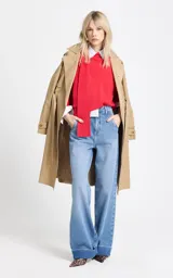 Blusa de punto color rojo con diseño de cuello asimétrico que incorpora una bufanda integrada. Presenta mangas anchas de largo tres cuartos y un corte holgado.
