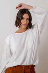 Blusa de algodón color bordó, con diseño de volados en los hombros, mangas largas con puños elásticos y corte holgado.