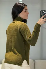 Buzo de punto con cuello alto, diseño de textura acanalada en el frente y mangas largas con puños ajustados.