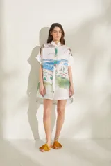 Vestido corto de lino blanco con estampado artístico de paisaje costero, cuello mao y mangas cortas holgadas.