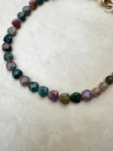 Collar de piedras naturales de ágata talladas en forma de corazón, con tonos verdes y violáceos, unidos por una fina cadena metálica.