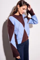 Sweater de tejido de punto con diseño de rombos (argyle) en tonos azul claro y marrón oscuro. Presenta cuello redondo y puños y cintura acanalados.