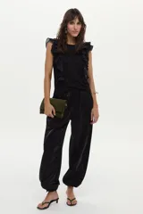 Pantalón estilo babucha de tafeta negra, con cintura elástica y puños ajustables en los tobillos.