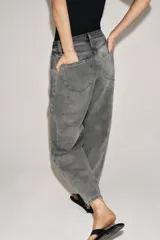 Jeans de tiro medio con corte relajado y largo al tobillo. Presenta diseño de cinco bolsillos, trabillas en la cintura y cierre frontal con cremallera y botón metálico.