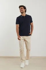 Chomba azul marino de piqué con cuello clásico y tapeta de dos botones. Detalles de ribete blanco en cuello y mangas.