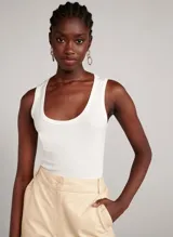 Musculosa blanca de tejido de punto rib, corte ajustado, tirantes medianos y escote en U.