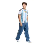 Camiseta de fútbol Adidas de la Selección Argentina, modelo Home 2026. Diseño a rayas verticales blancas y celestes con detalles en negro en cuello y mangas. Incluye logo de Adidas, escudo de AFA y parche de campeón del mundo.