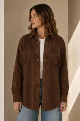 Camisa tipo overshirt de gamuza marrón óxido con flecos en el pecho, cuello camisero, bolsillos delanteros y cierre frontal de botones metálicos a presión.