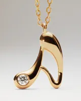 Collar de plata con baño de oro, con una cadena de eslabones y un colgante en forma de letra "A" estilizada que incluye una circonita engastada.