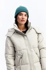 Campera puffer larga con capucha, color beige, de ajuste relajado. Presenta cierre frontal con botones a presión, bolsillos laterales con cierre y puños tejidos acanalados.
