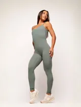 Jumpsuit deportivo de una pieza, color verde militar, con breteles finos y diseño ajustado al cuerpo. Confeccionado en tejido de alta performance con efecto modelador.