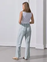 Pantalón de lino con pretina ancha en punto smock con lazo, bolsillos verticales delanteros y bolsillos aplicados traseros.