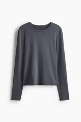 Remera deportiva gris de manga larga, con cuello redondo y corte ajustado, confeccionada en tejido funcional con tecnología DryMove.