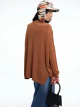 Sweater de punto color gris, con escote en V profundo, hombros caídos y diseño holgado de corte relajado.