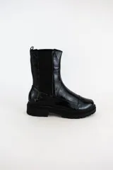 Bota tipo chelsea de cuero acharolado negro, con elásticos laterales y suela track dentada.