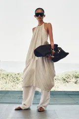 Maxi bolso color marrón con efecto rafia, doble asa de mano rígida con detalles metálicos dorados y cierre con botón imantado.