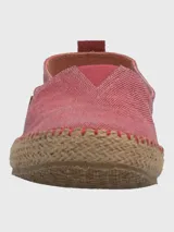 Alpargatas Hush Puppies de estilo slip-on, color bordó con textura de tejido de algodón. Presenta una suela de yute trenzado con costuras decorativas y una etiqueta lateral de la marca.