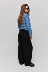 Pantalón sastrero de pierna amplia, color negro, con tiro medio, cintura con pasacintos, cierre frontal con botón y cremallera, bolsillos laterales y bolsillos ojal decorativos en la parte posterior.