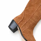 Bota alta de gamuza 100% cuero color marrón capuchino, con punta fina, taco bajo ancho y costuras artesanales decorativas a lo largo de la caña.